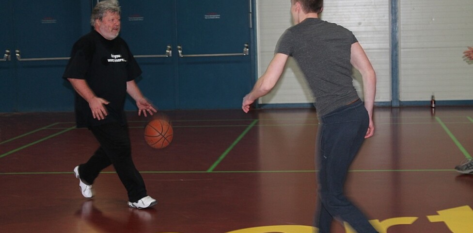 Schüler und Lehrer spielen Basketball